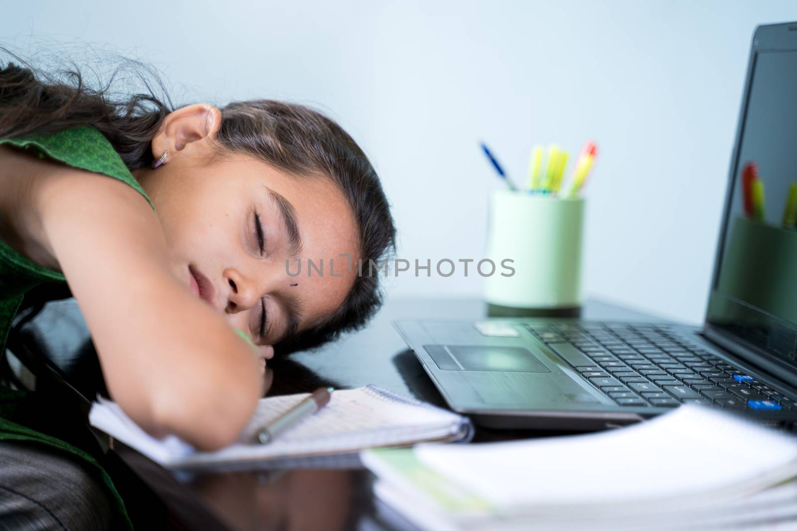 Bored Girl child slept infront of laptop - concept of kid tired from e-learning or online education at home during covid-19 or coronavirus outbreak
