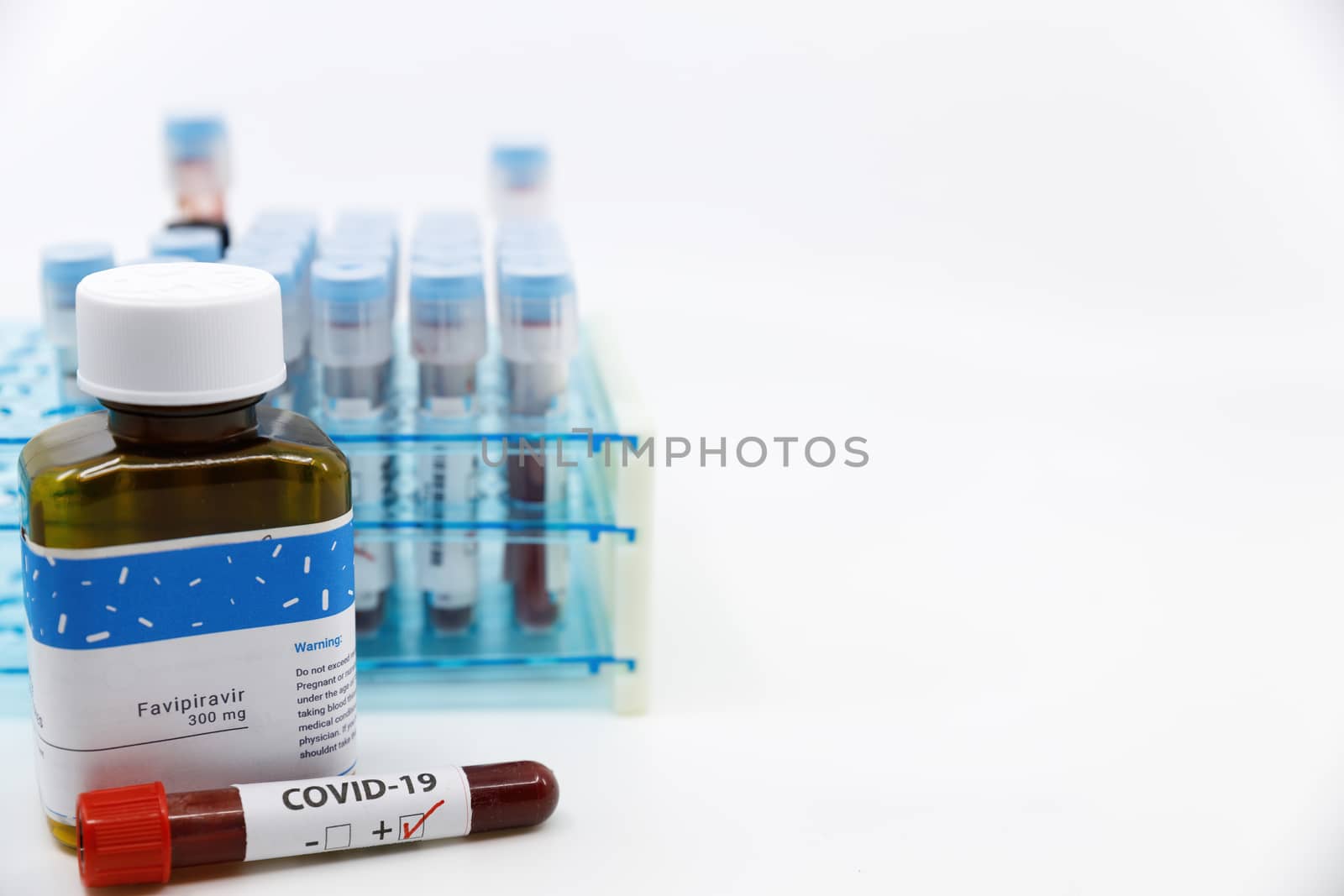 Dubai-UAE-Circa 2020:Coronavirus positive test in front of medicine.Concept of Favipiravir medicine with blood tests tubes on the background.Cure for coronavirus,COVID-19 treatment. by dugulan