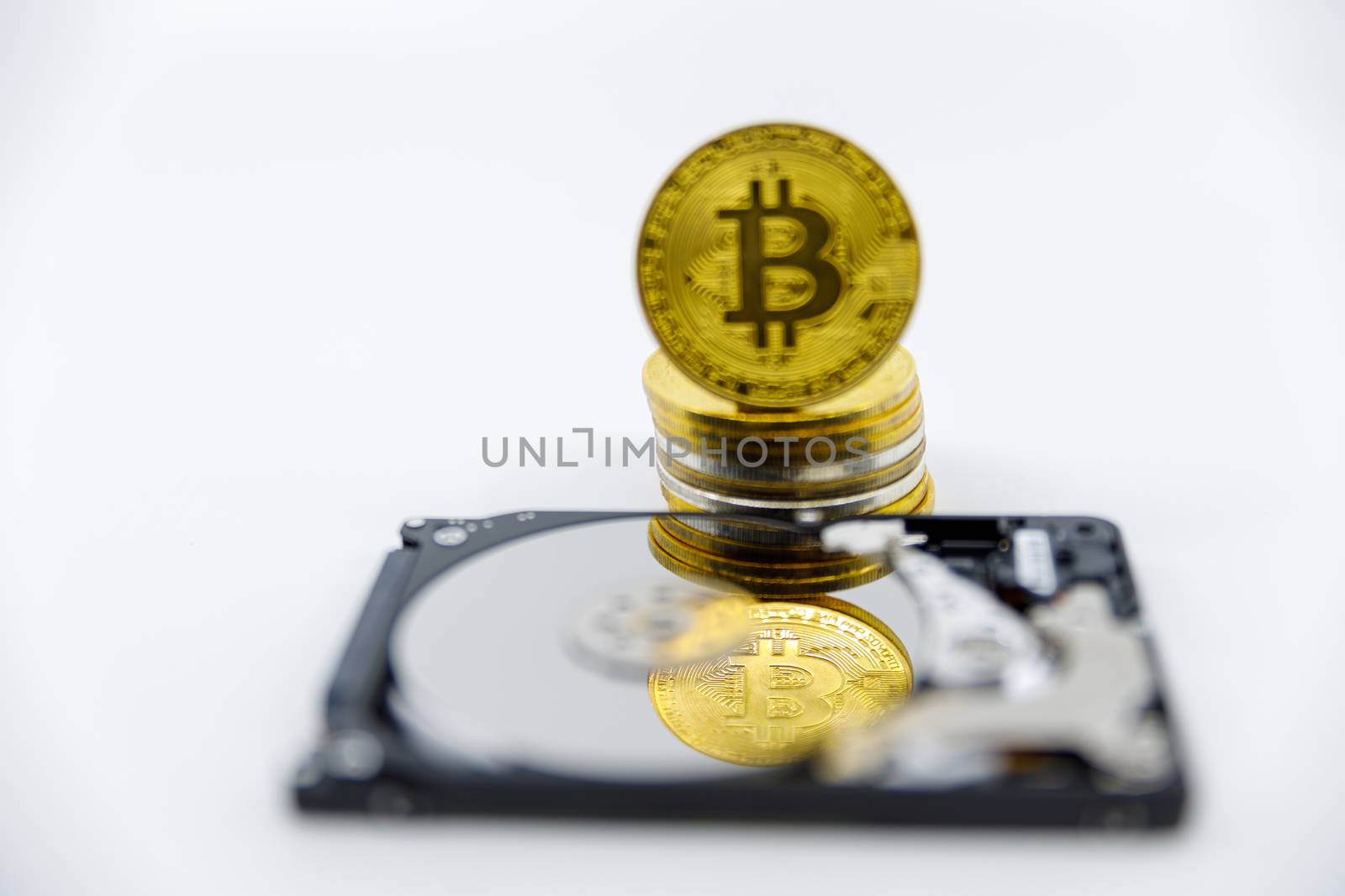 Stack of Gold bitcoin tokens on top of an open hard drive.Worldwide virtual internet cryptocurrency,digital payment system.Concept Digital coin money crypto currency on bitcoin farm.Copy space by dugulan