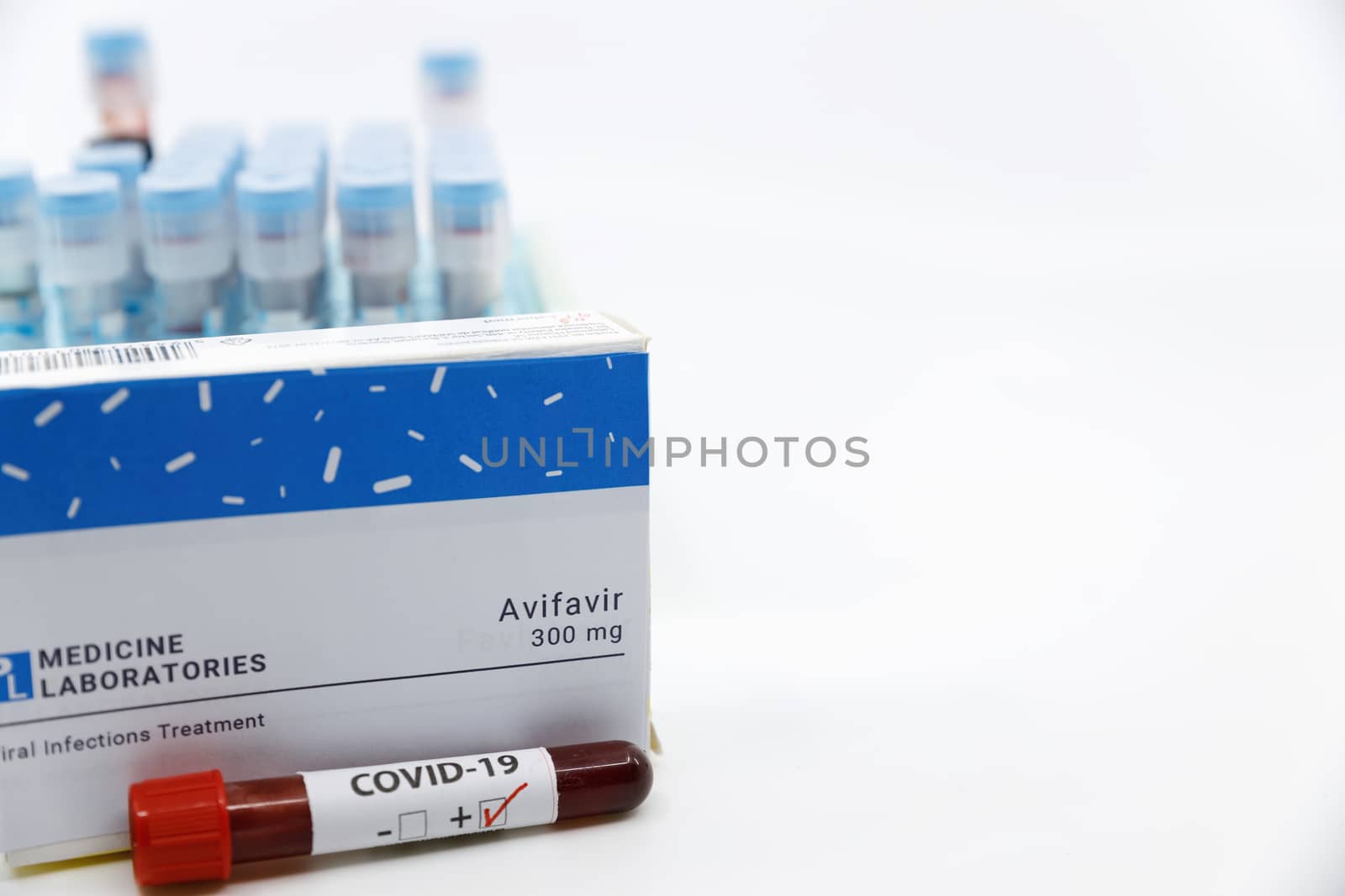 Dubai-UAE-Circa 2020:Coronavirus positive test in front of medicine.Concept of Avifavir medicine with blood tests tubes on the background.Cure for coronavirus,COVID-19 treatment.