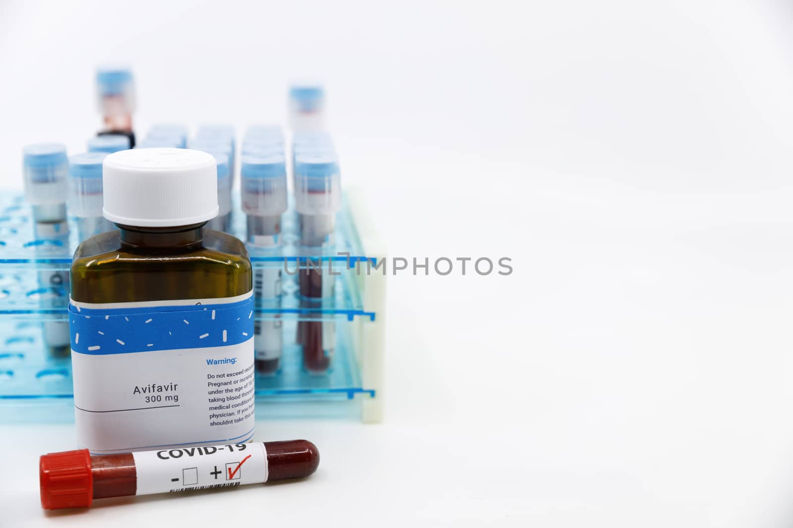 Dubai-UAE-Circa 2020:Coronavirus positive test in front of medicine.Concept of Avifavir medicine with blood tests tubes on the background.Cure for coronavirus,COVID-19 treatment. by dugulan