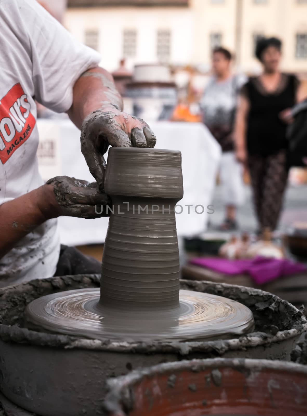 Sibiu City, Romania - 31 August 2019. Hands of a potter shaping a clay pot on a potter's wheel at the potters fair from Sibiu, Romania