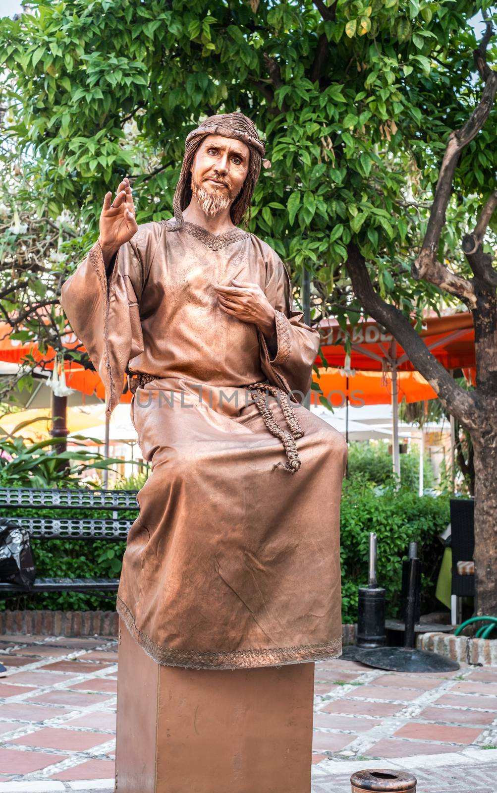 Marbella, Spain - June 27, 2018. Human statue of a Jesus performs on the Orange tree square, Plaza de los Naranjos, Marbella, Spain