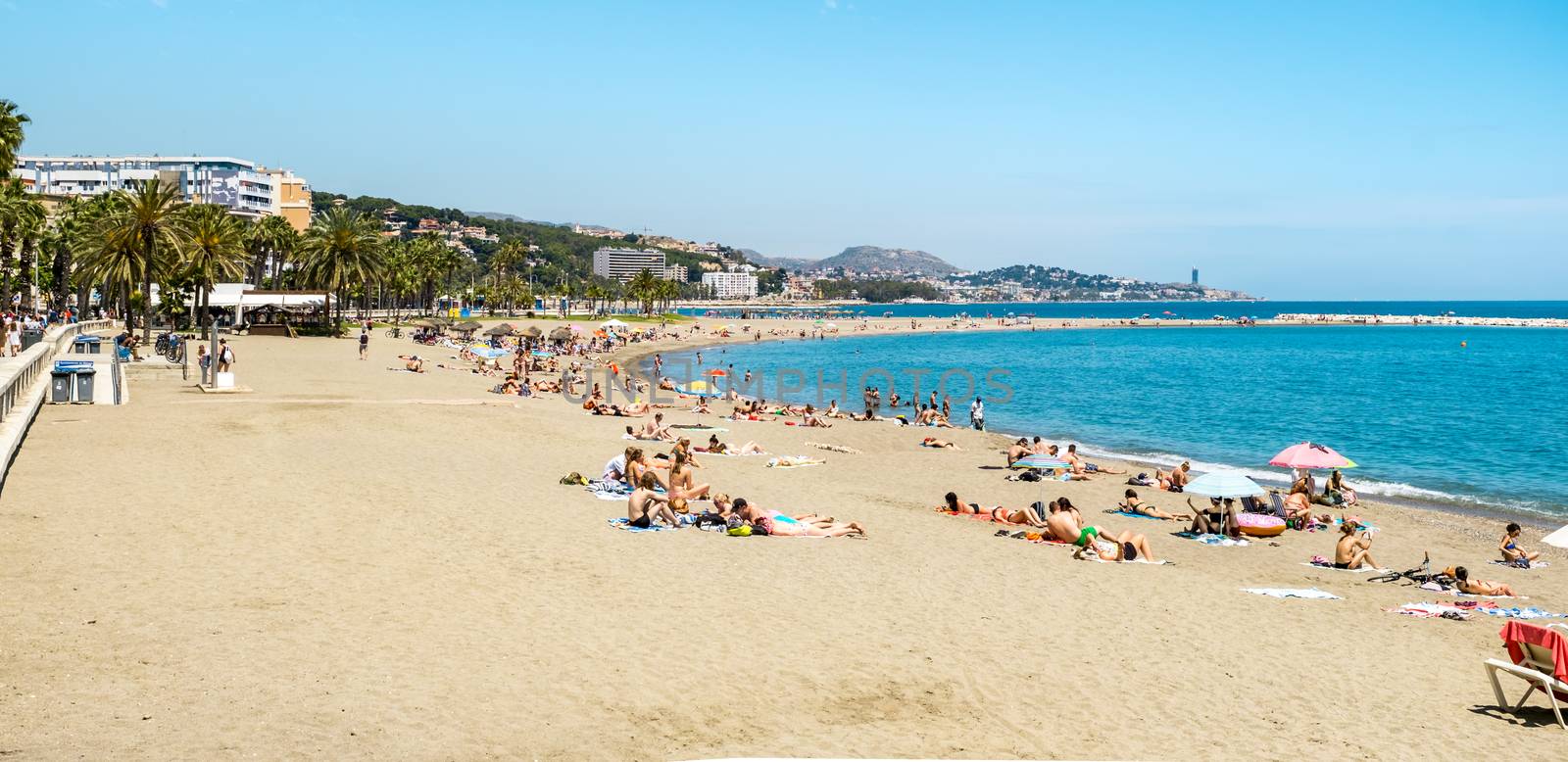 Malaga, Spain - May 26, 2018. Holidaymakers sunbathing on Malagueta beach, Malaga, Costa del Sol, Malaga Province, Andalucia, Spain, Western Europe
