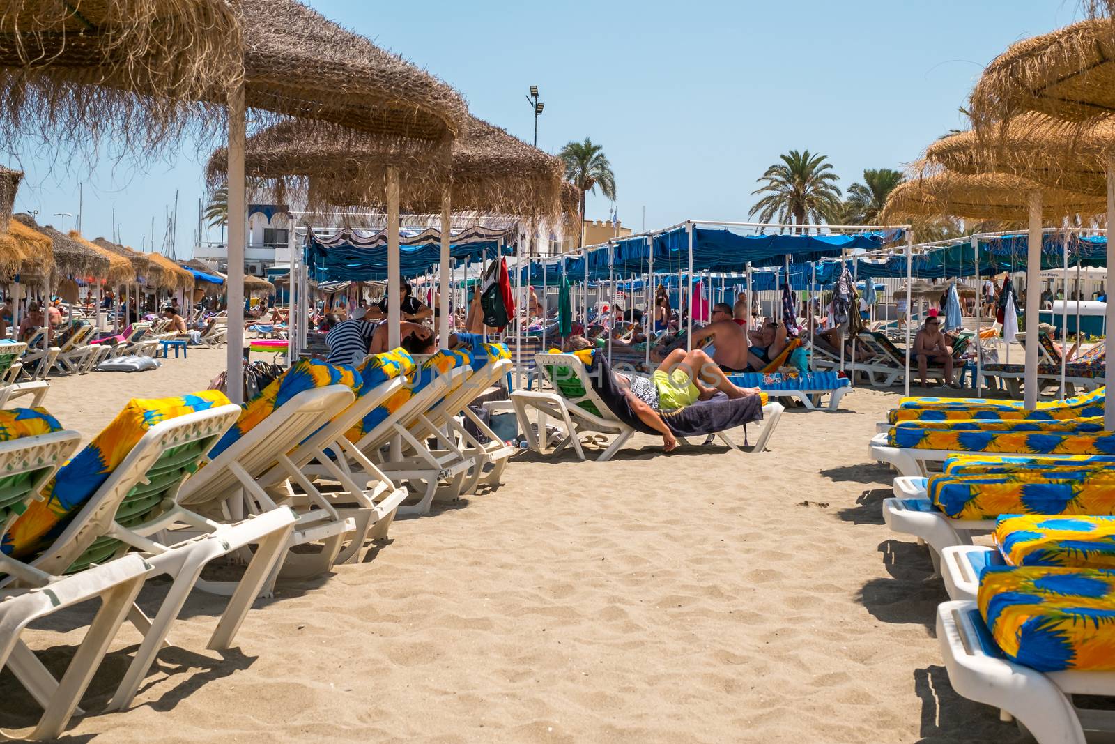 Fuengirola, Spain - June 31, 2018. people on sunbeds at the Cepa beach, Fuengirola city and resort area, province of Malaga, Andalucia region, Spain, Western Europe.