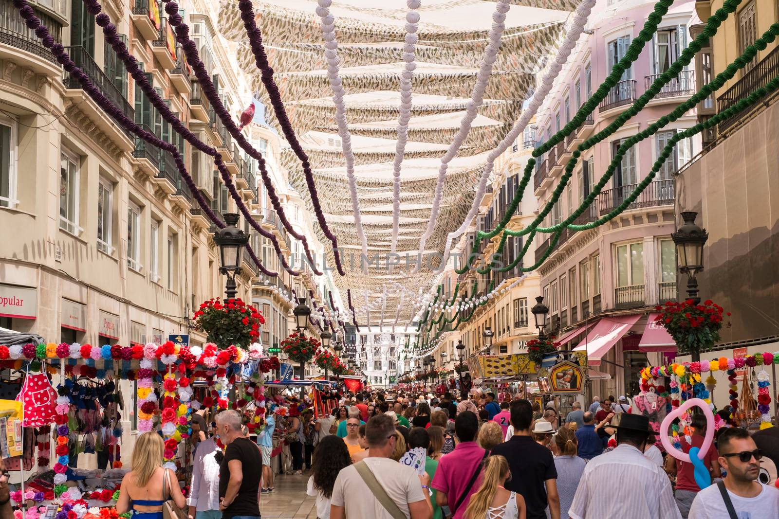 Malaga, Spain - August 12, 2018. People on the Marques de Larios pedestrian street at the Feria de Malaga, an annual event that takes place in mid-August and is one of the largest fiestas in Spain