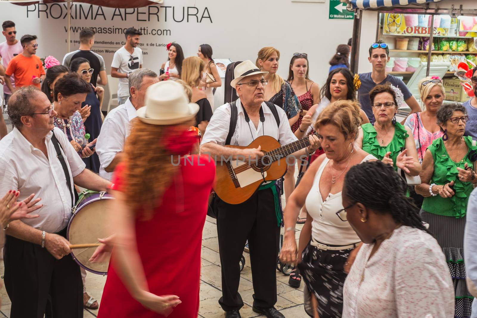Malaga, Spain - August 17, 2018. People having fun on the street at the Feria de Malaga, an annual event that takes place in mid-August and is one of the largest fiestas in Spain