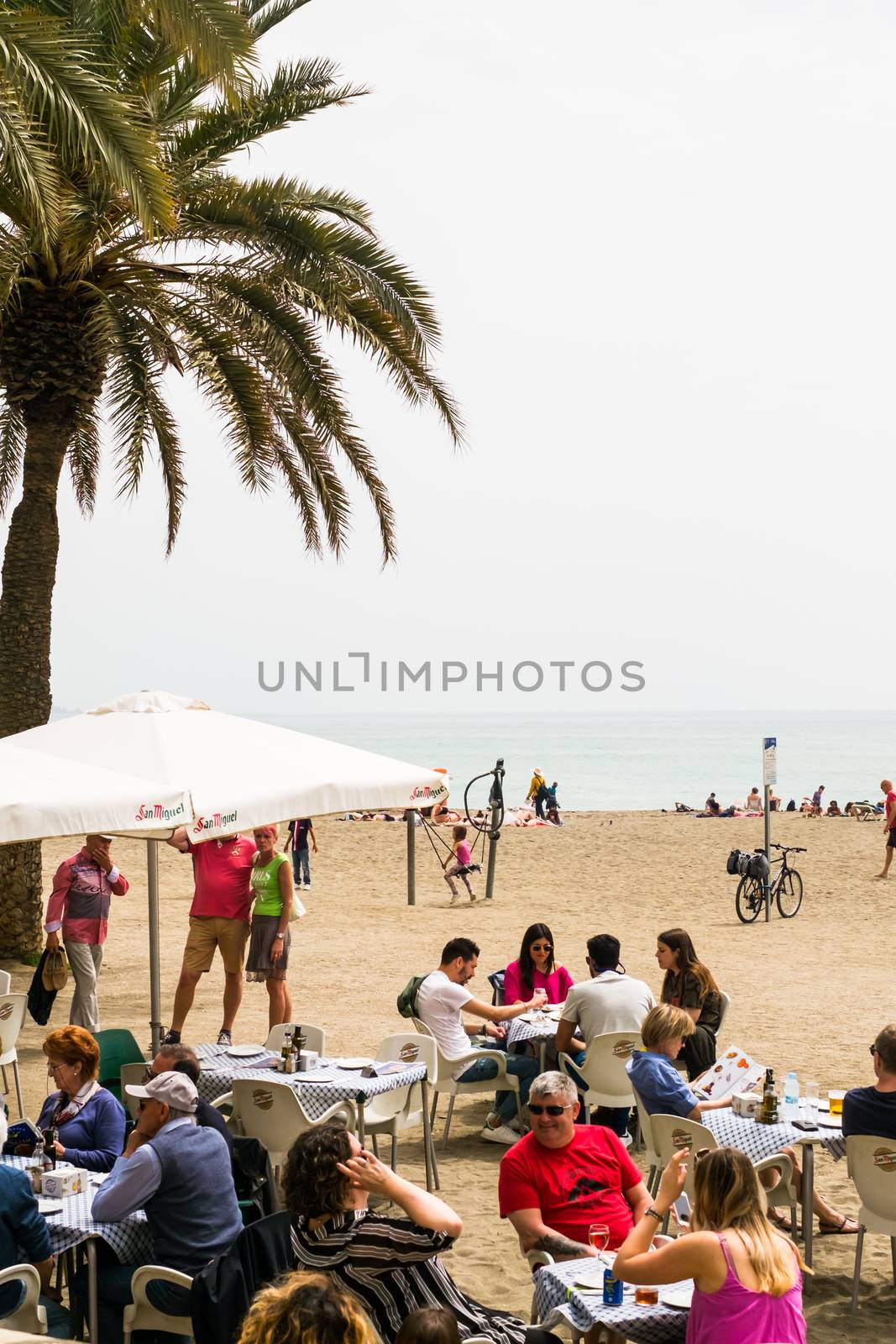 Malaga, Spain - April 21, 2018. People at the restaurant on the beach, Malaga city, Spain