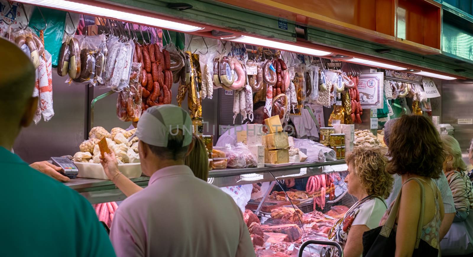 Malaga, Spain - August 04, 2018. Spanish prosciutto or jamon iberico and other Spanish specialities at the market of Ataranzanas Central Market, Malaga, Spain
