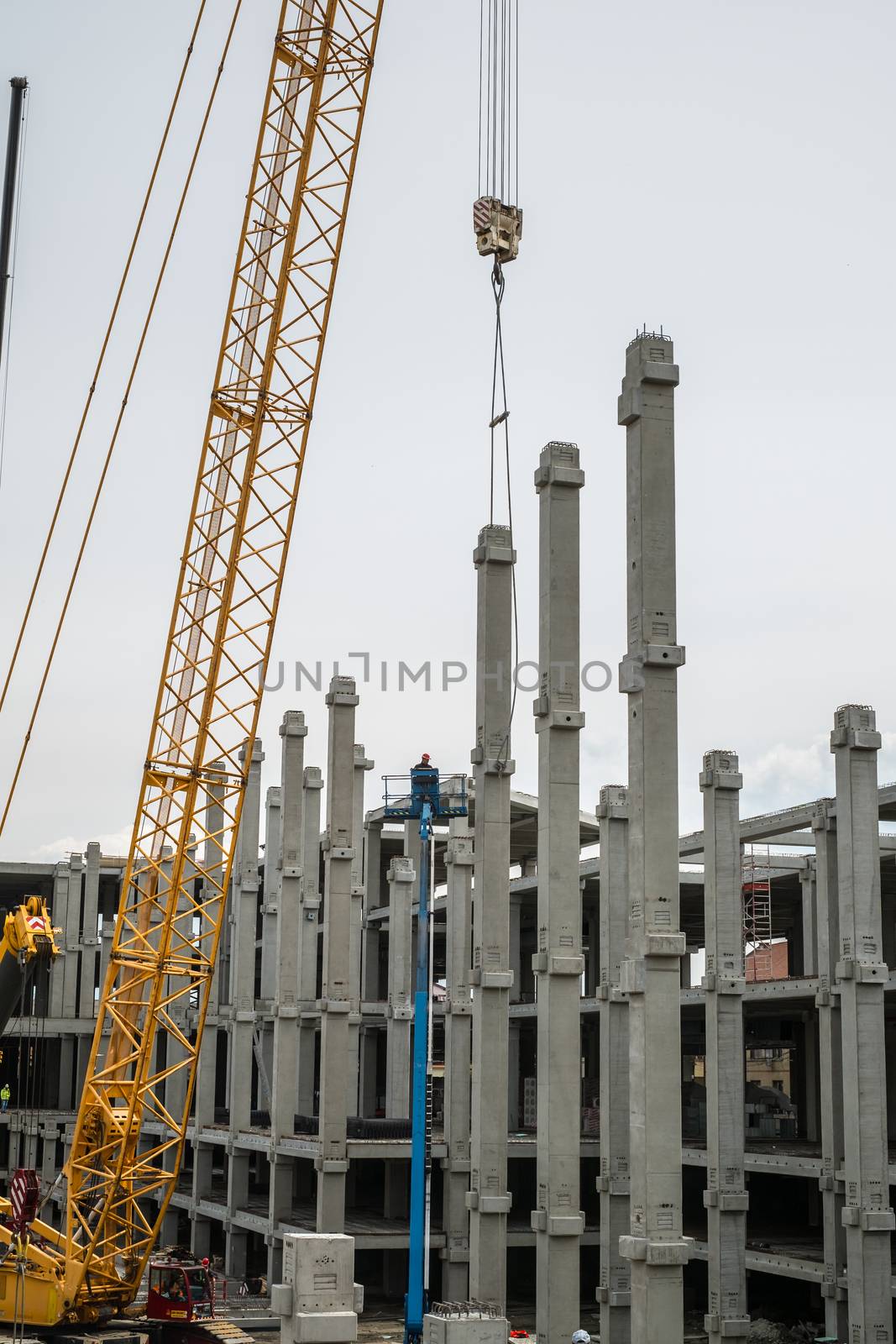 Sibiu, Romania - April 06, 2019. workers with cranes at The mall Festival Centrum building site from Sibiu city, Romania