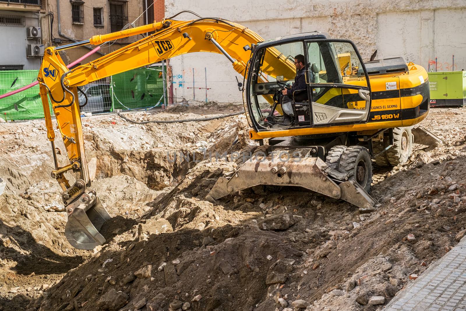 Malaga, Spain - March 23, 2018. Working Excavator Tractor Digging A Trench