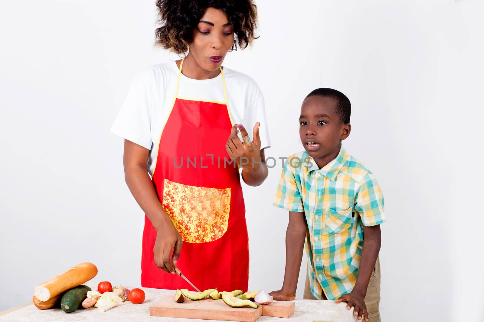 Young woman and her child preparing a meal with avocado. by vystek