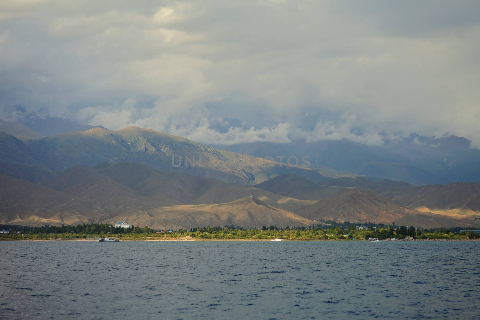 Beautiful mountain landscape. The shore of Lake Issyk-Kul. Wildlife of Kyrgyzstan. Clouds in the sky. High quality photo