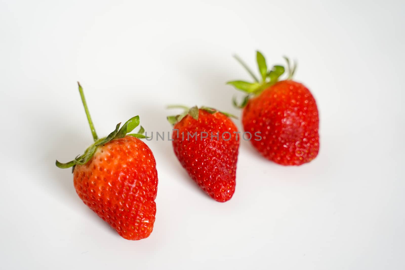 Three strawberries against a plain white background