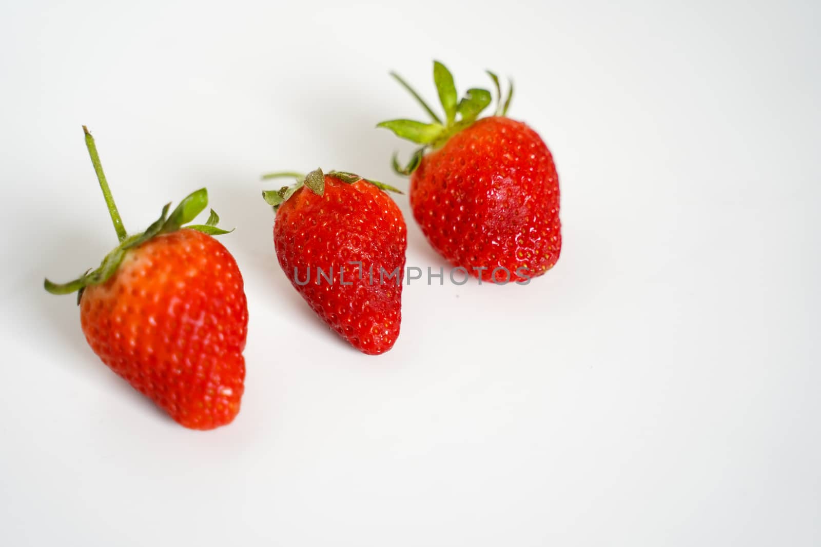 Three strawberries against a plain white background