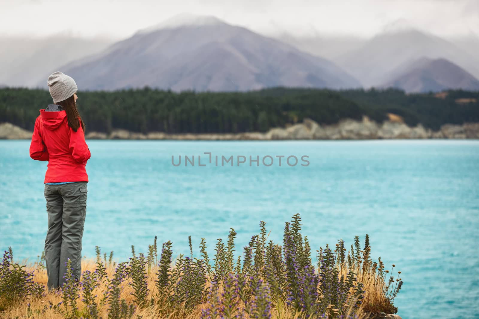 New Zealand travel - Tourist hiker on Road Trip looking at nature view of Lake Pukaki by Aoraki aka Mount Cook, a famous travel tourist destination.