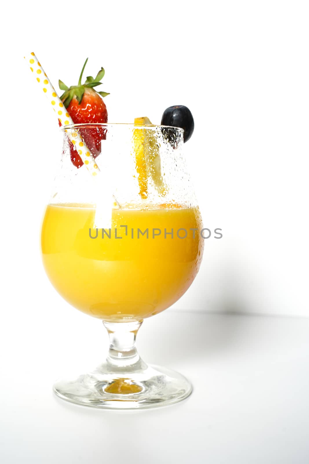 An orange cocktail drink with a party straw against a plain white background