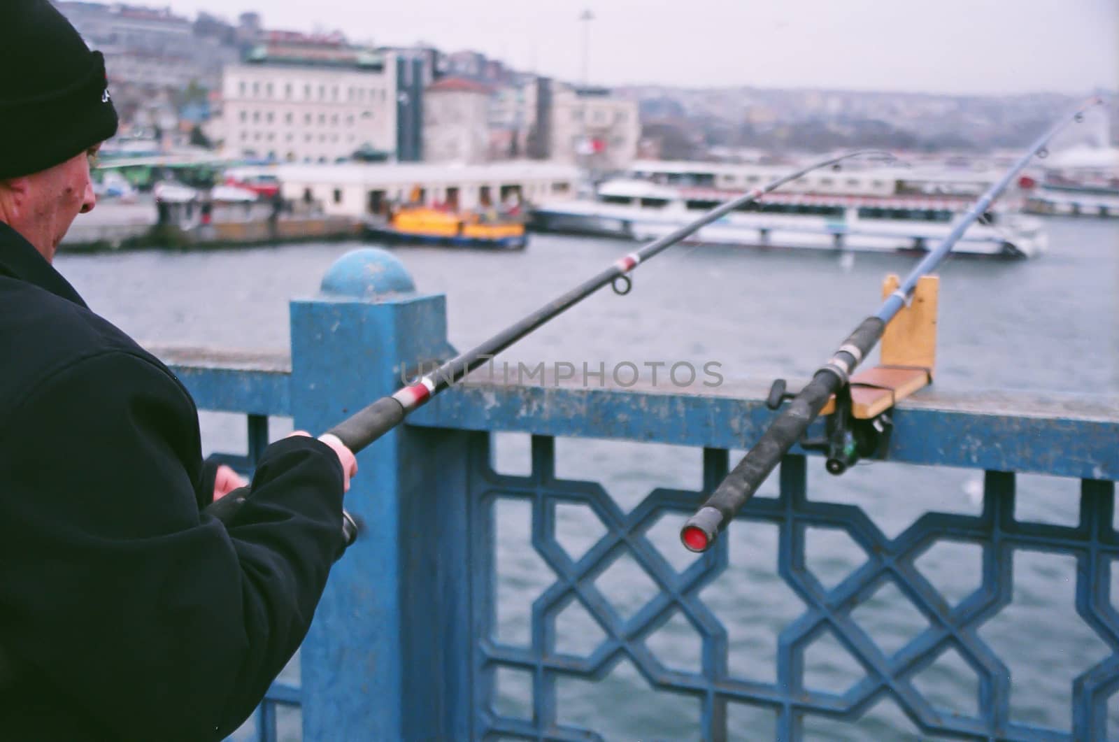 Istanbul, Turkey - February 24, 2007: Fishermen and urban scene, at the Galata Bridge, Istanbul, Turkey