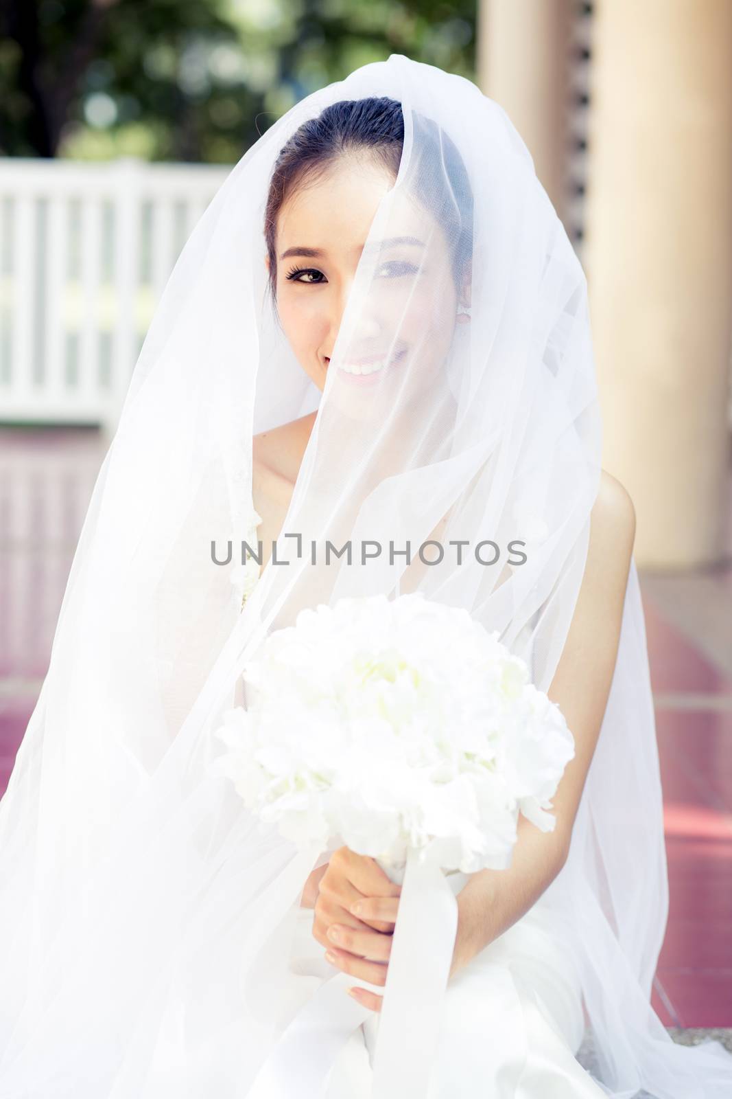 Portrait of a beautiful bride covering her face with a veil. Bri by nnudoo