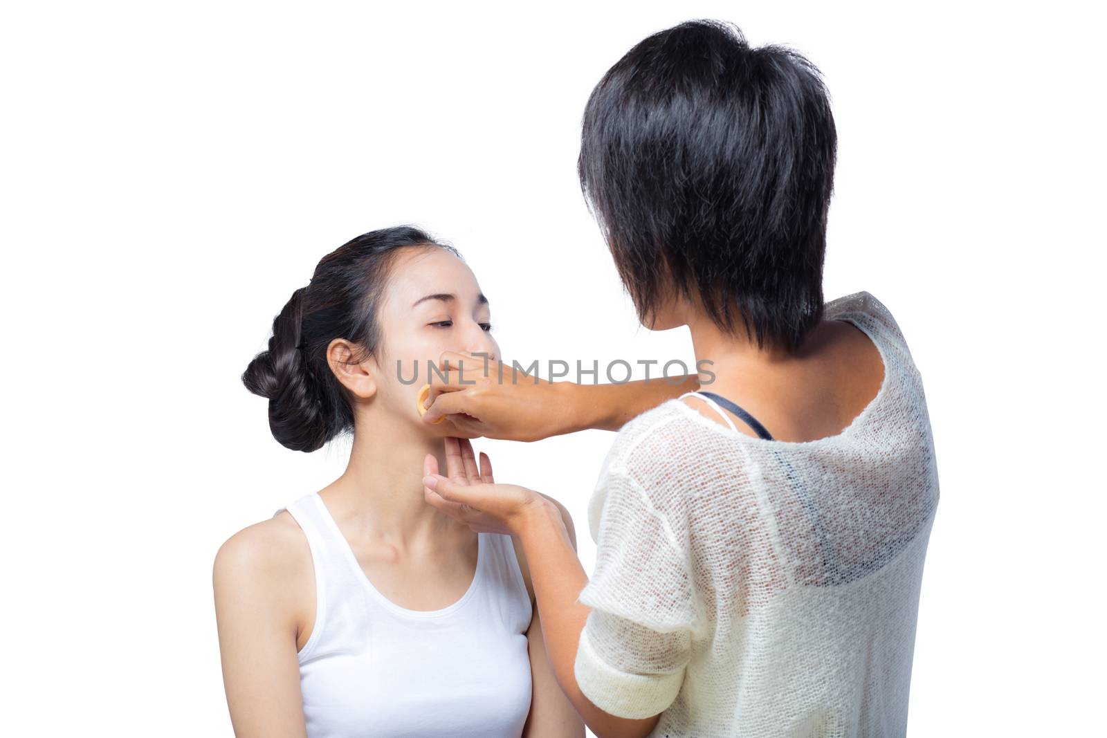 Young lady applying blusher on her face with powder puff, skin care concept.