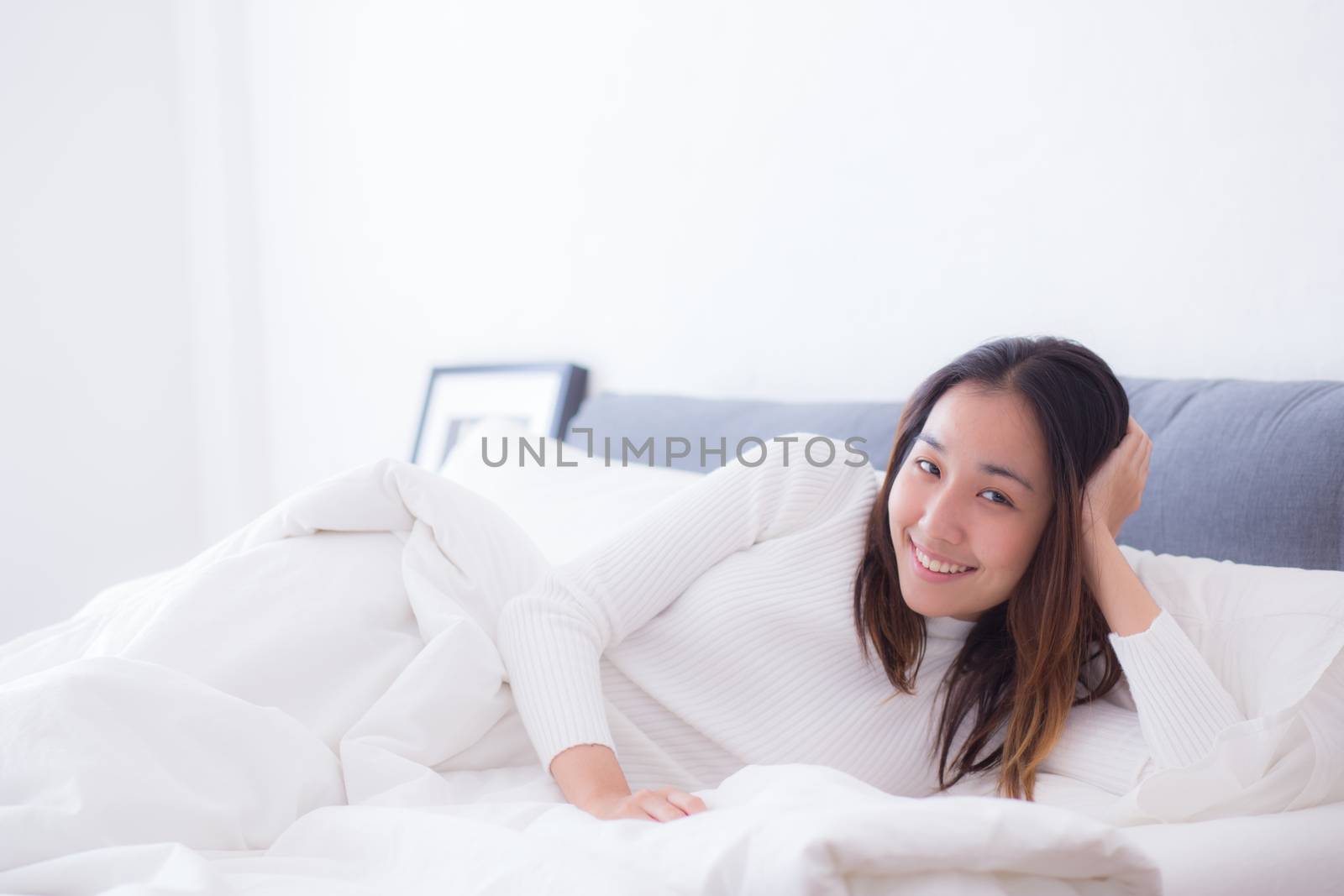 A pleased sleeping on the side young woman smiling softly in bed