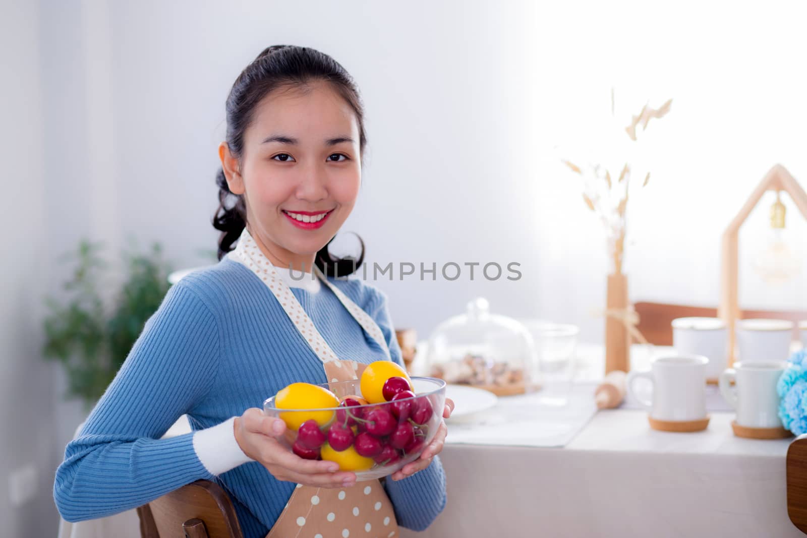 Pretty female holding bowl with a smile in kitchen by nnudoo