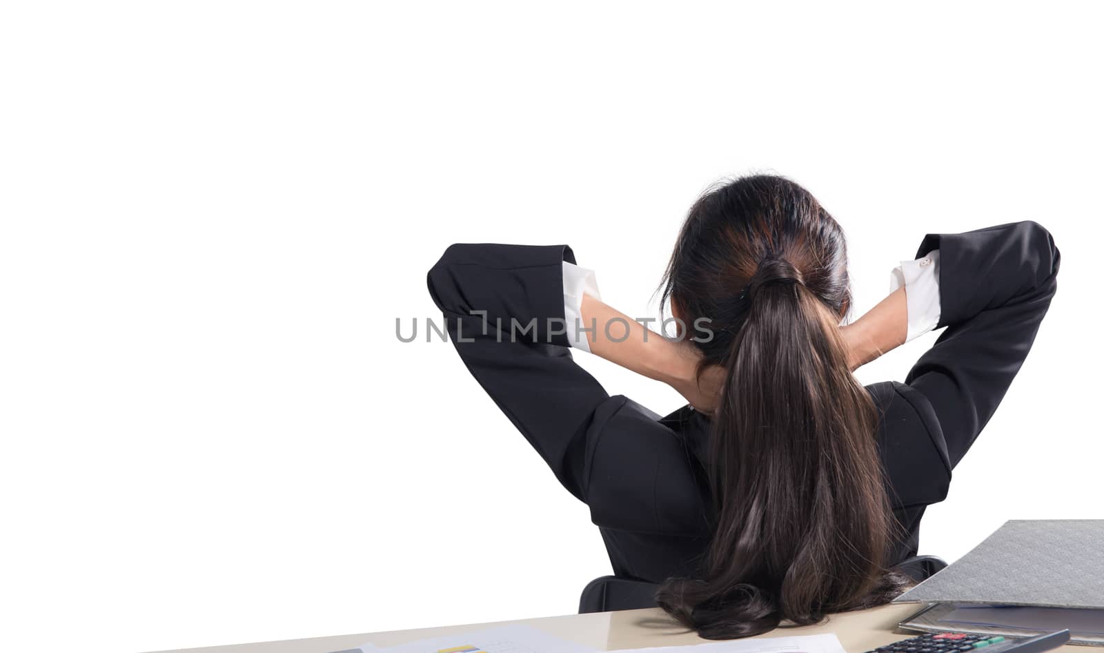 Closeup portrait of cute young relaxed business woman from behind with open hands behind her head on work space