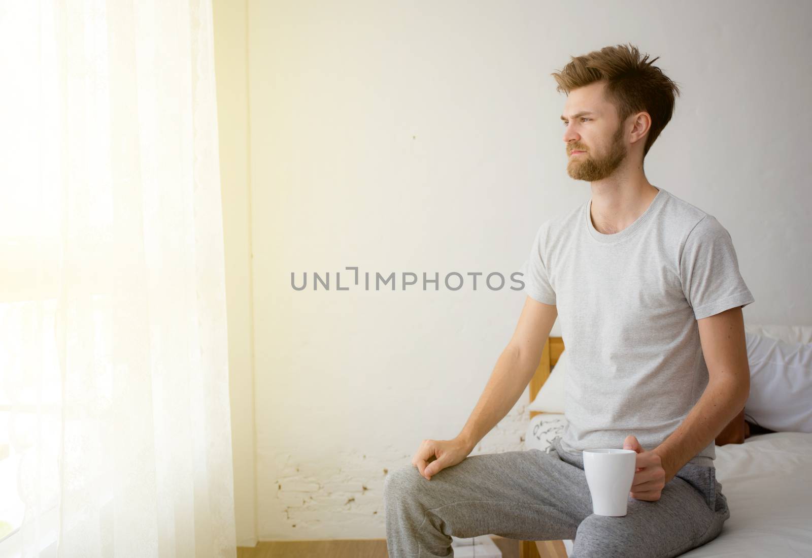 Portrait of bedroom concept: He has a cup of coffee with on his  by nnudoo