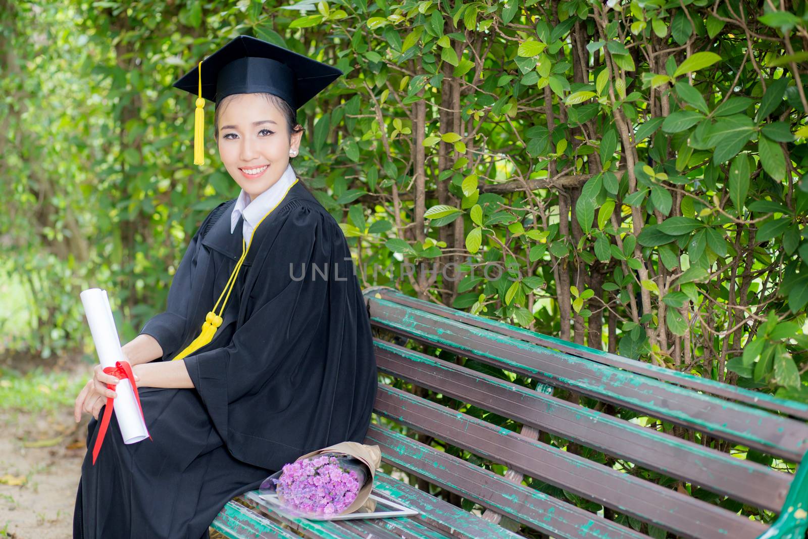 Portrait of happy young female graduates in academic dress by nnudoo