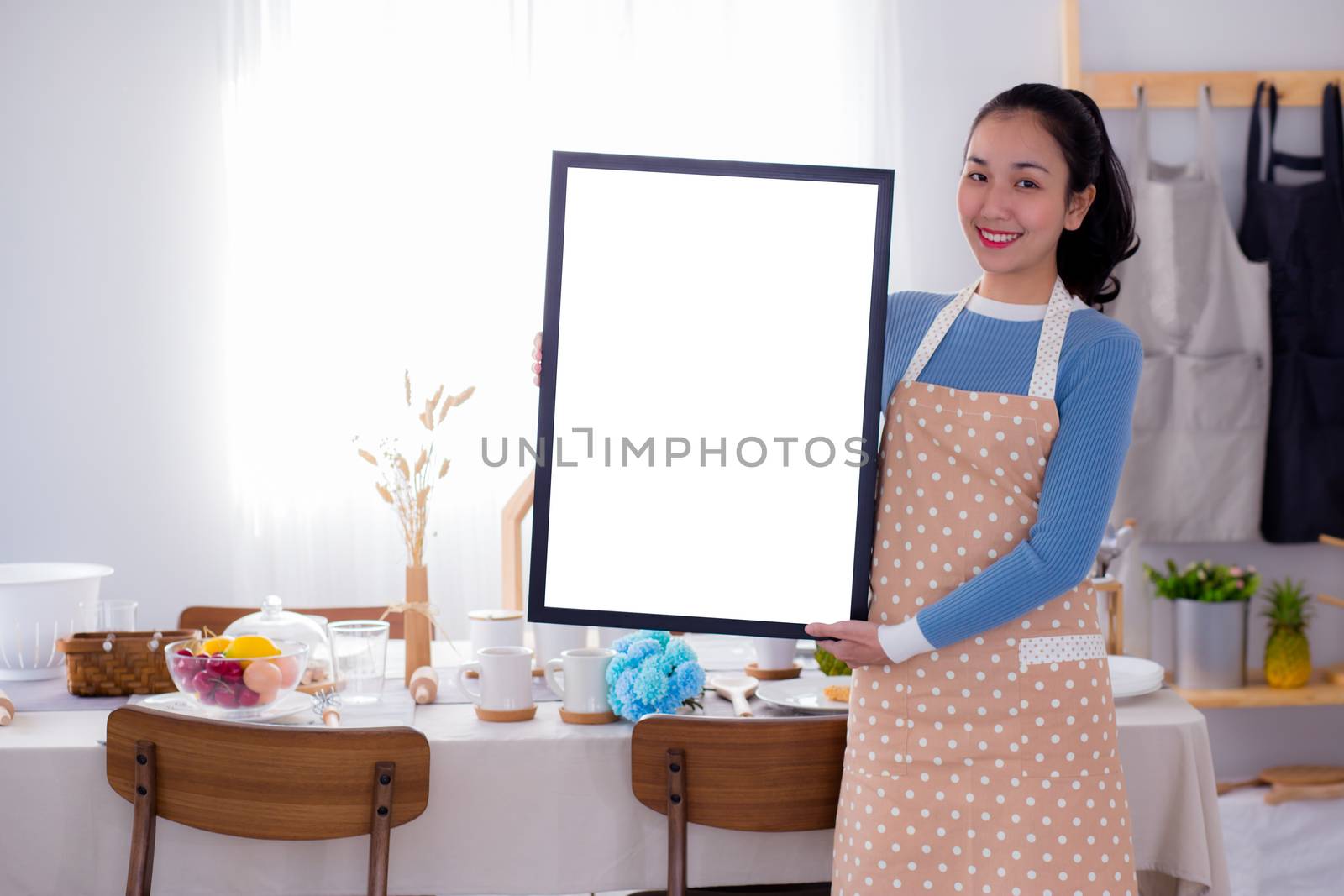 woman chef showing blank empty board menu sign for restaurant menu or recipe with food table background.