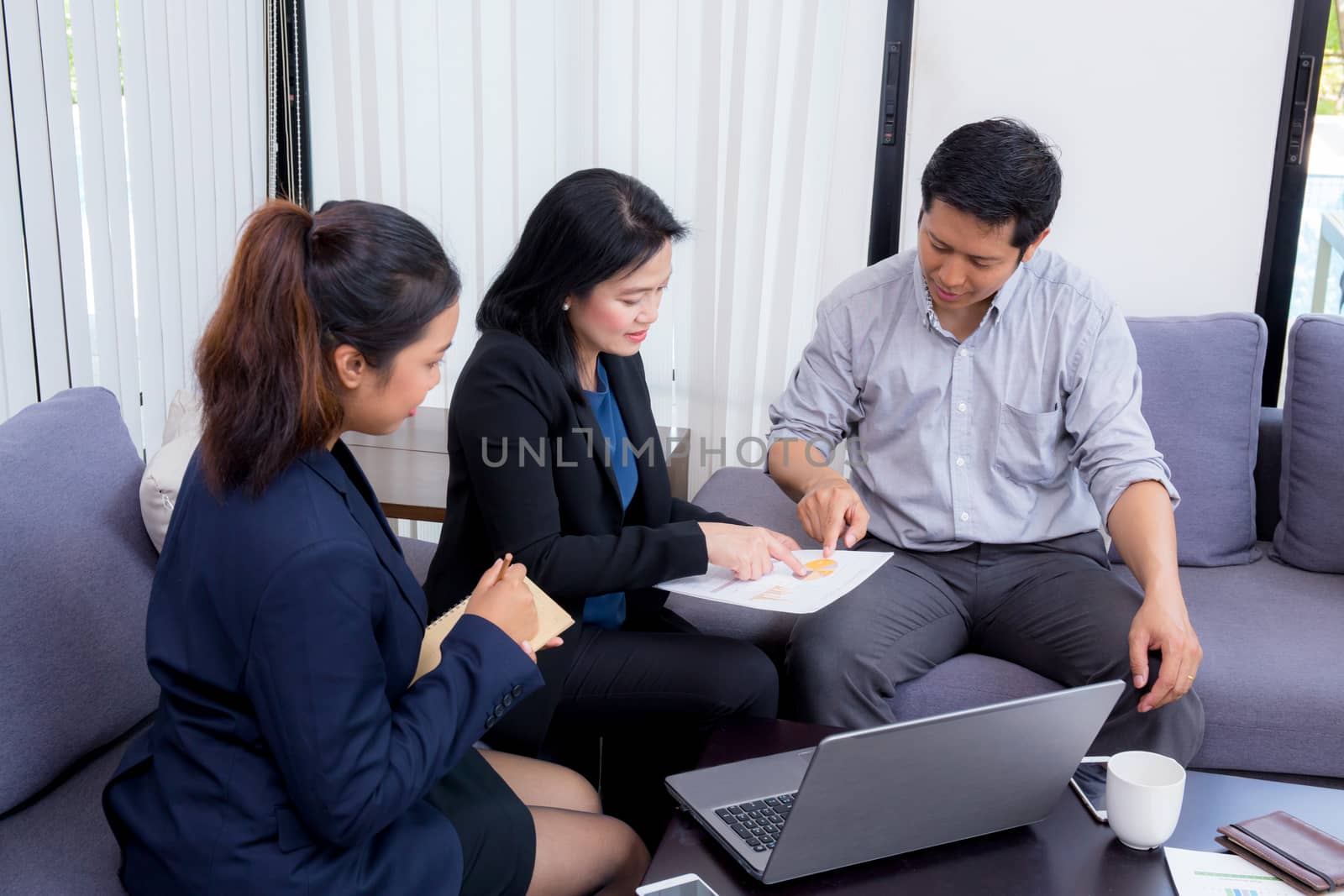 Team of business three people working together on a laptop with  by nnudoo