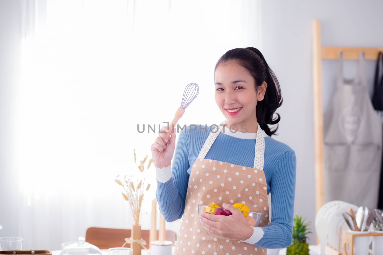 Pretty female holding bowl with a smile in kitchen by nnudoo