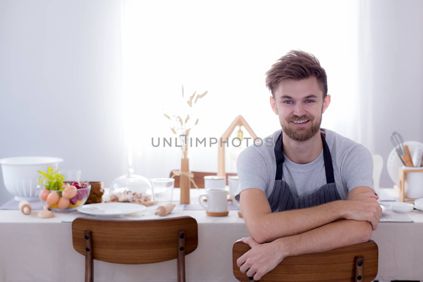 Man chef smiling looking camera with kitchen background
