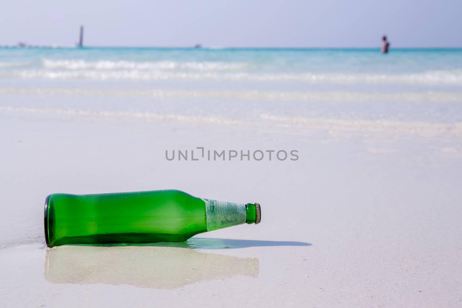 Beer bottle on a sandy beach.