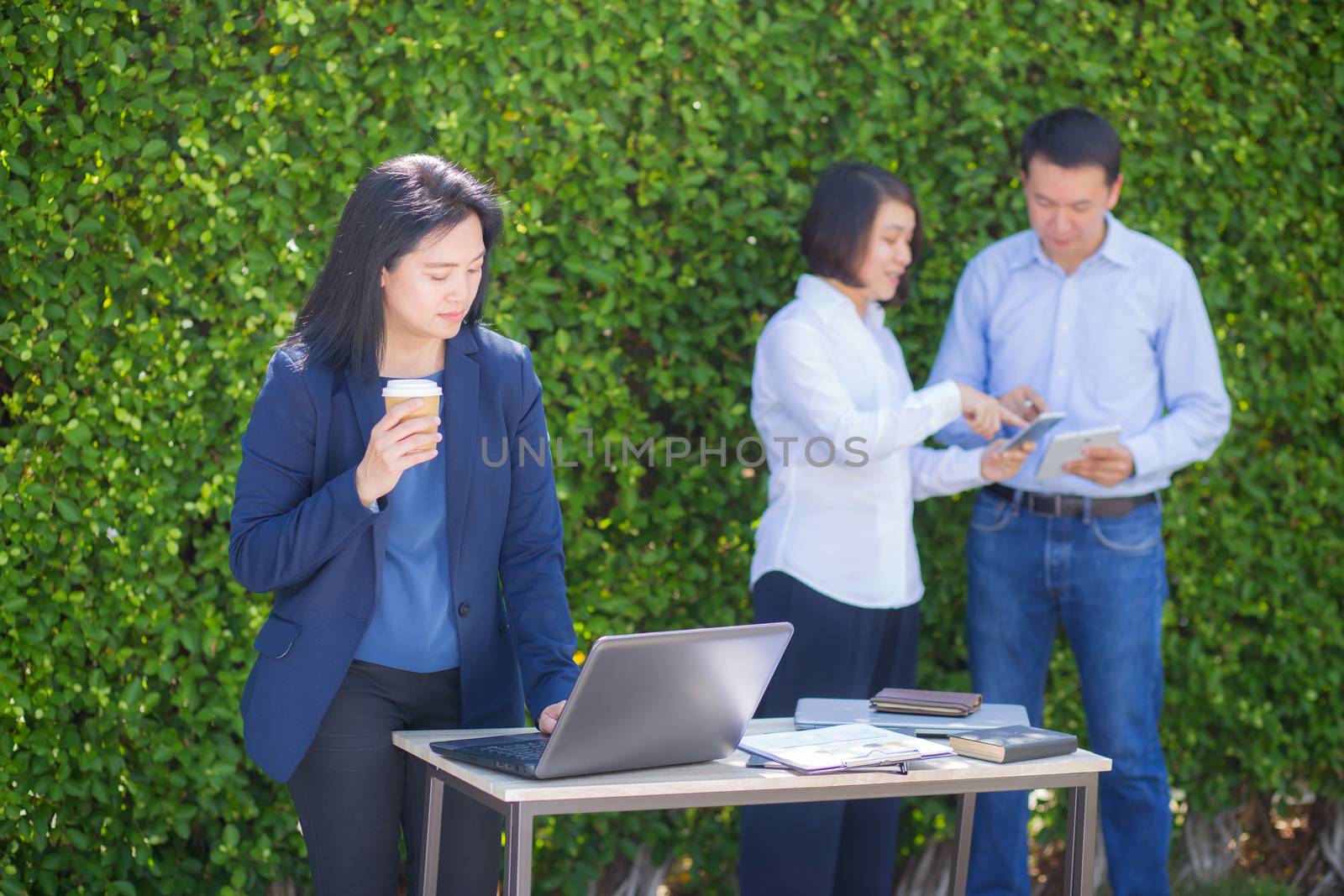 Young attractive businesswoman with the notebook in the garden tree wall background.