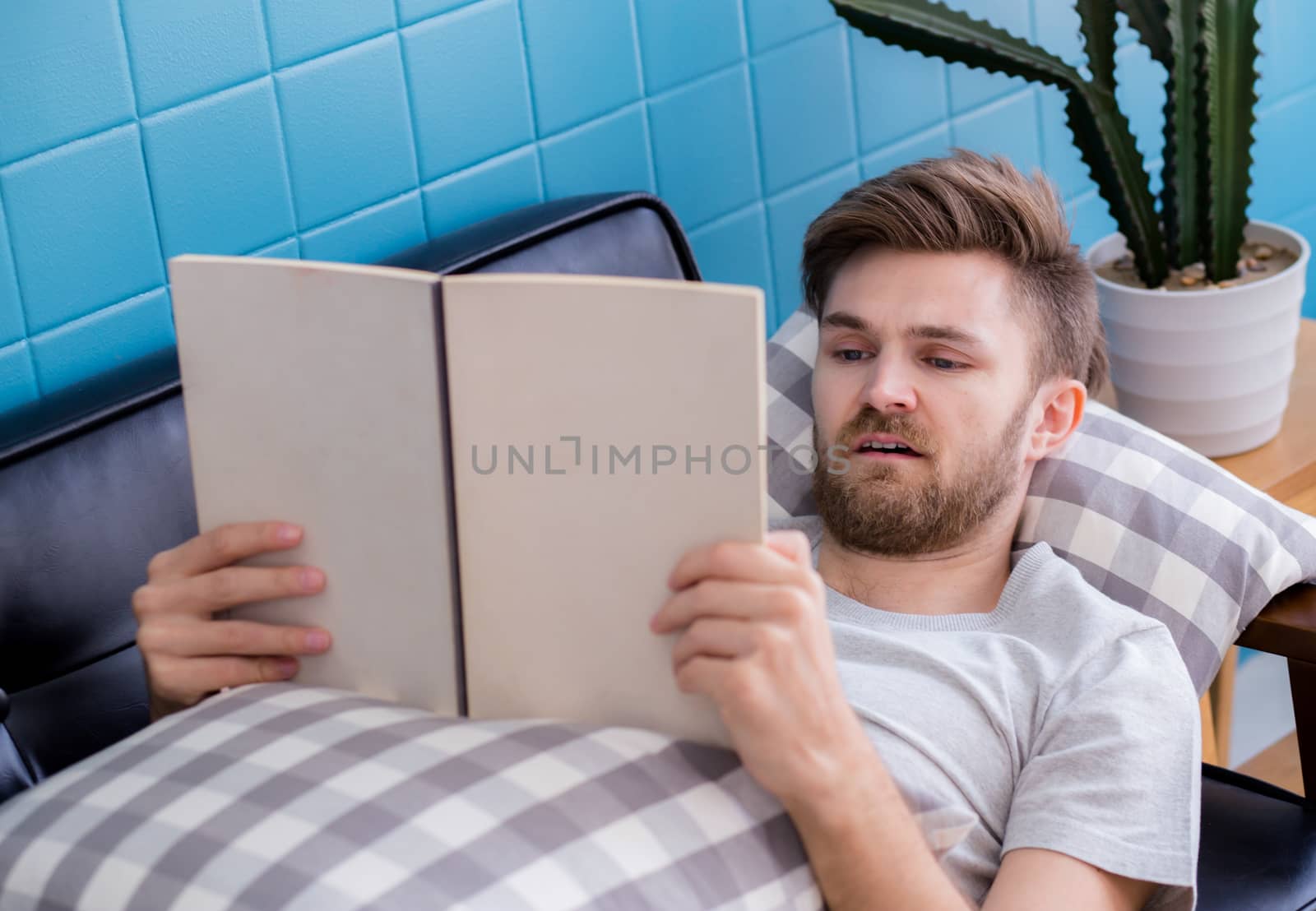 relax man reading a book lying on sofa education concept.