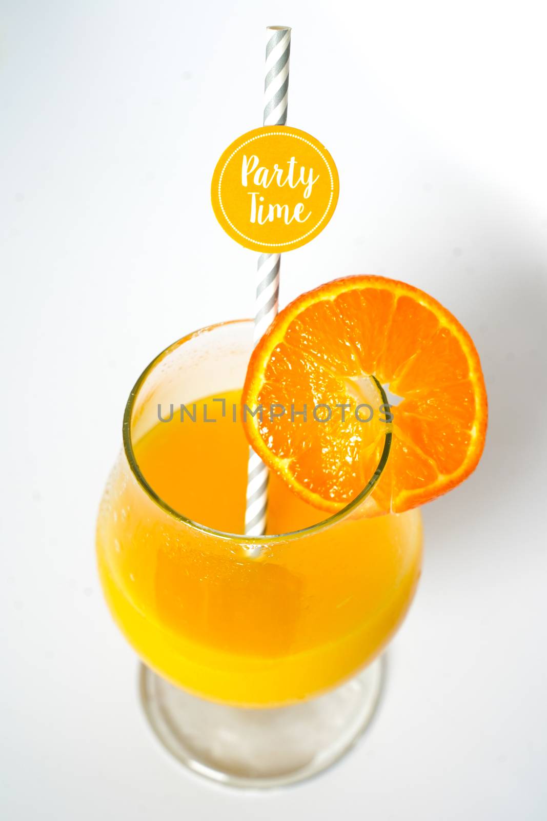 An orange cocktail drink with a party straw against a plain white background