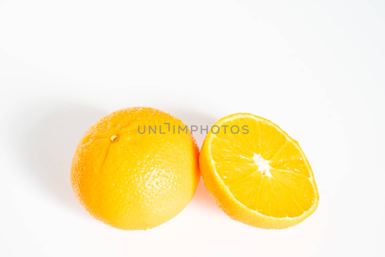 A whole orange and a half against a plain white background