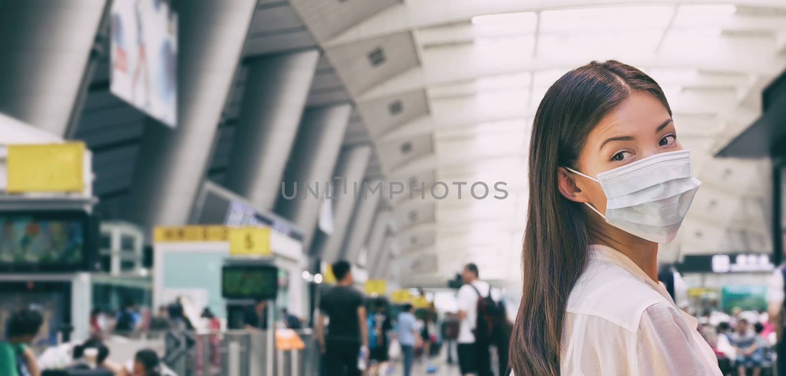 Woman wearing surgical mask in train or bus station walking indoors. Prevention in public spaces by Maridav