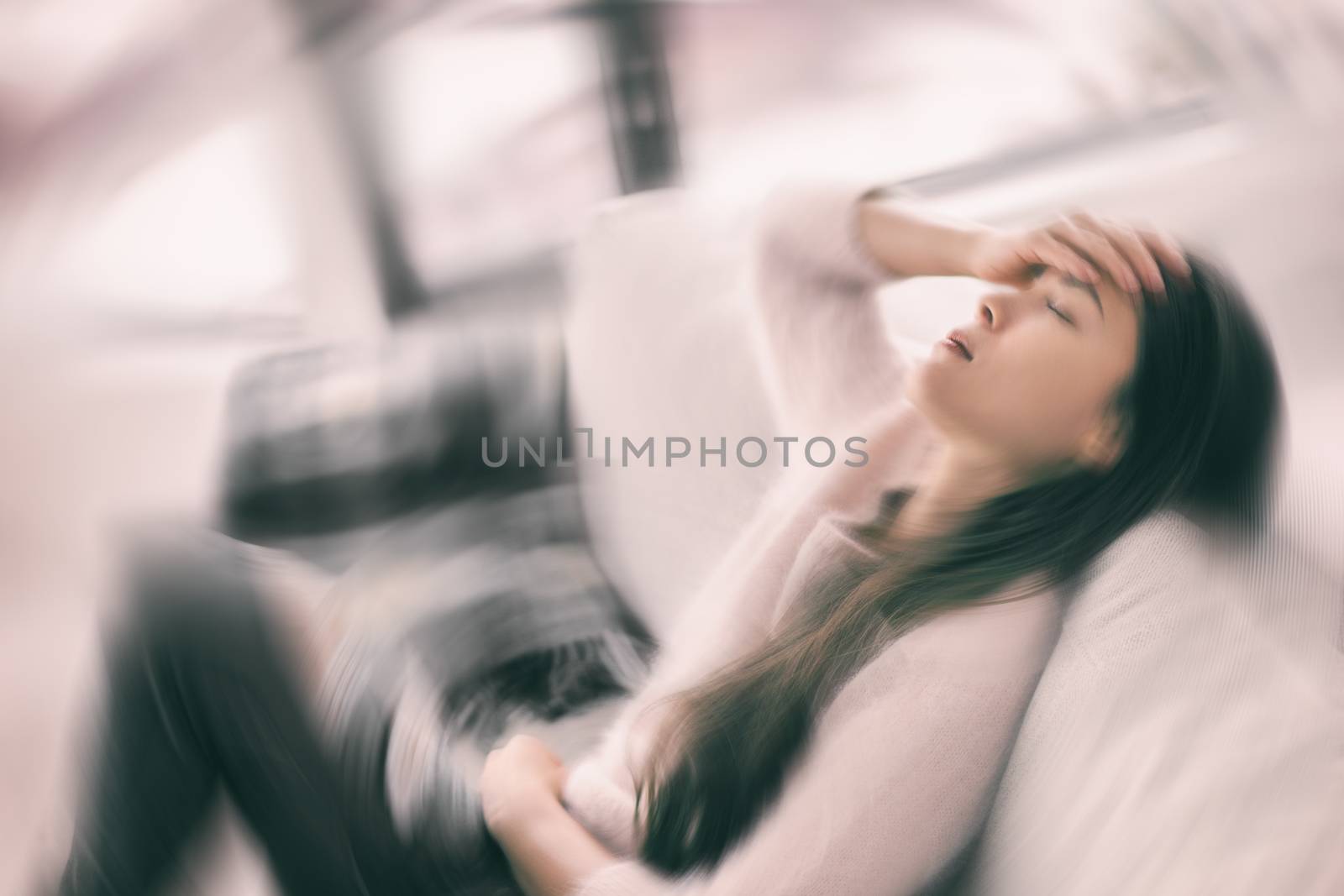 Sick woman with headache feeling faint vertigo holding head in pain with fever and migraine. Blurry motion blur background by Maridav