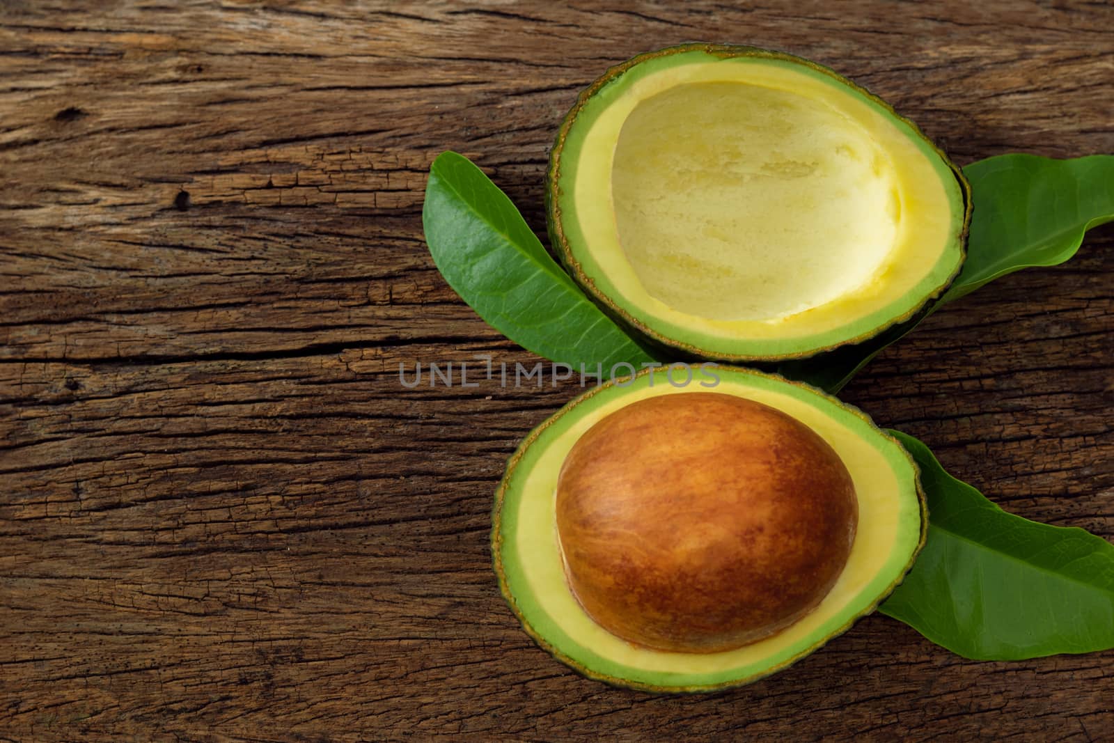 Avocado on a brown wooden floor  by sompongtom