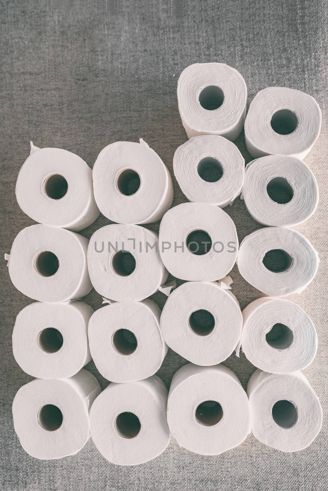 Toilet paper rolls background top flat view of many open rolls, vertical copy space. Hoarding of bathroom tissues in fear of store supply shor tage during coronavirus COVID-19 panic buying.