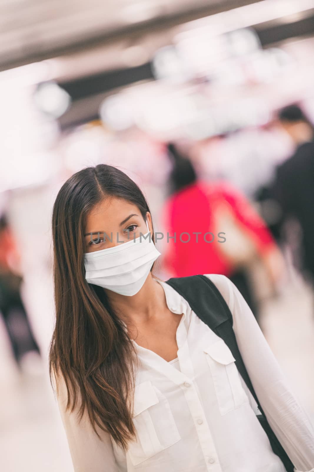 Virus mask Asian woman travel wearing face protection in prevention for coronavirus in China. Lady walking in public space bus station or airport by Maridav