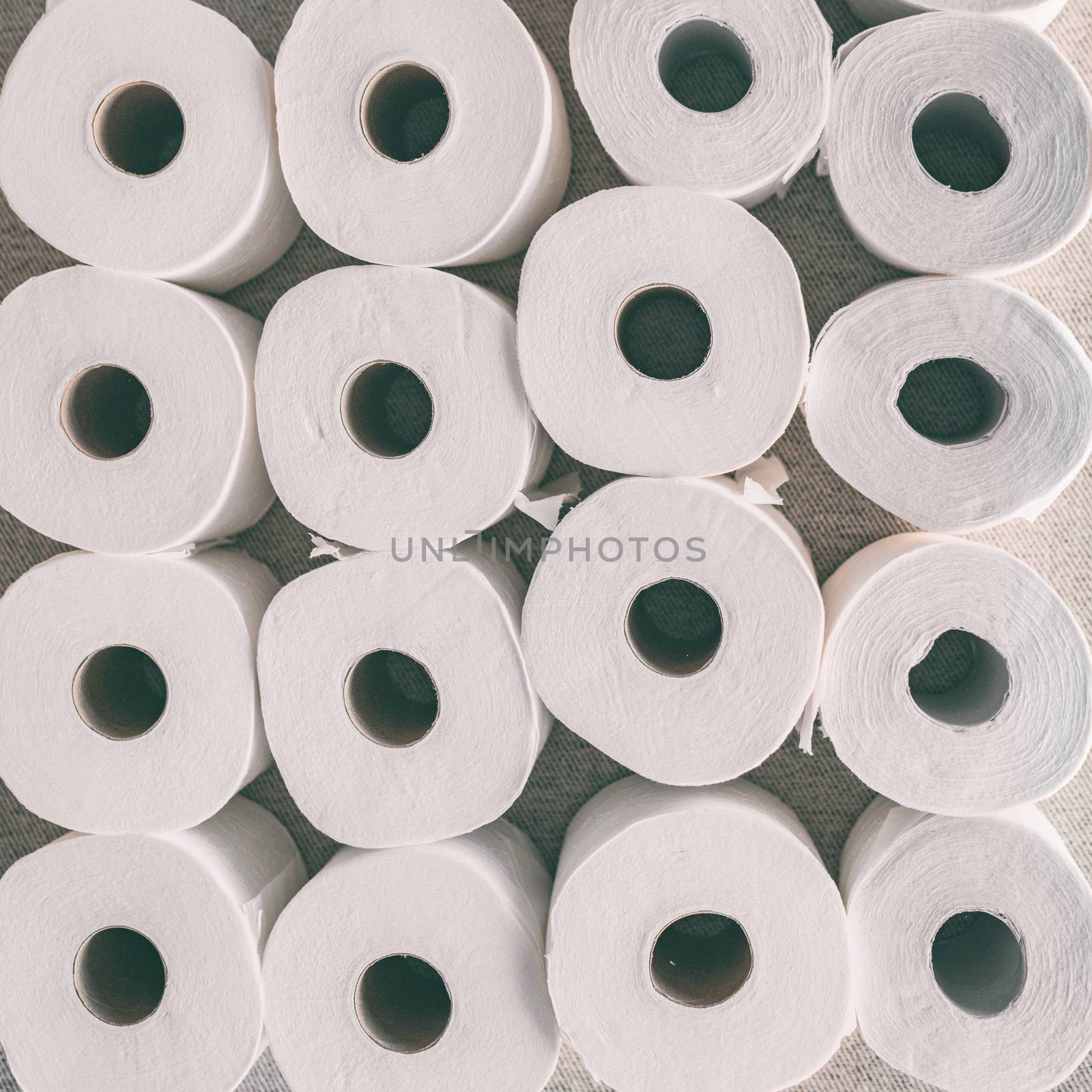 Toilet paper rolls background top flat view of many open rolls, square crop by Maridav