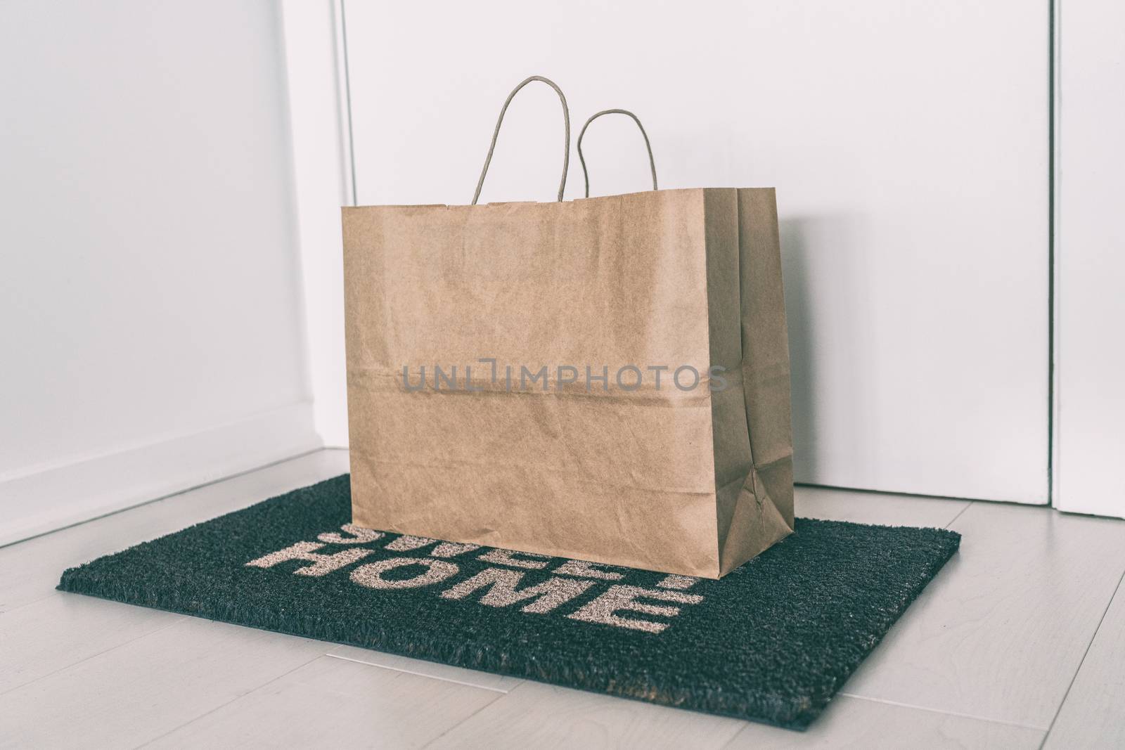 Home delivery of food grocery bag left at door mat for Corona virus spreading safety. Precaution measures against COVID-19, paper bag delivered without contact.