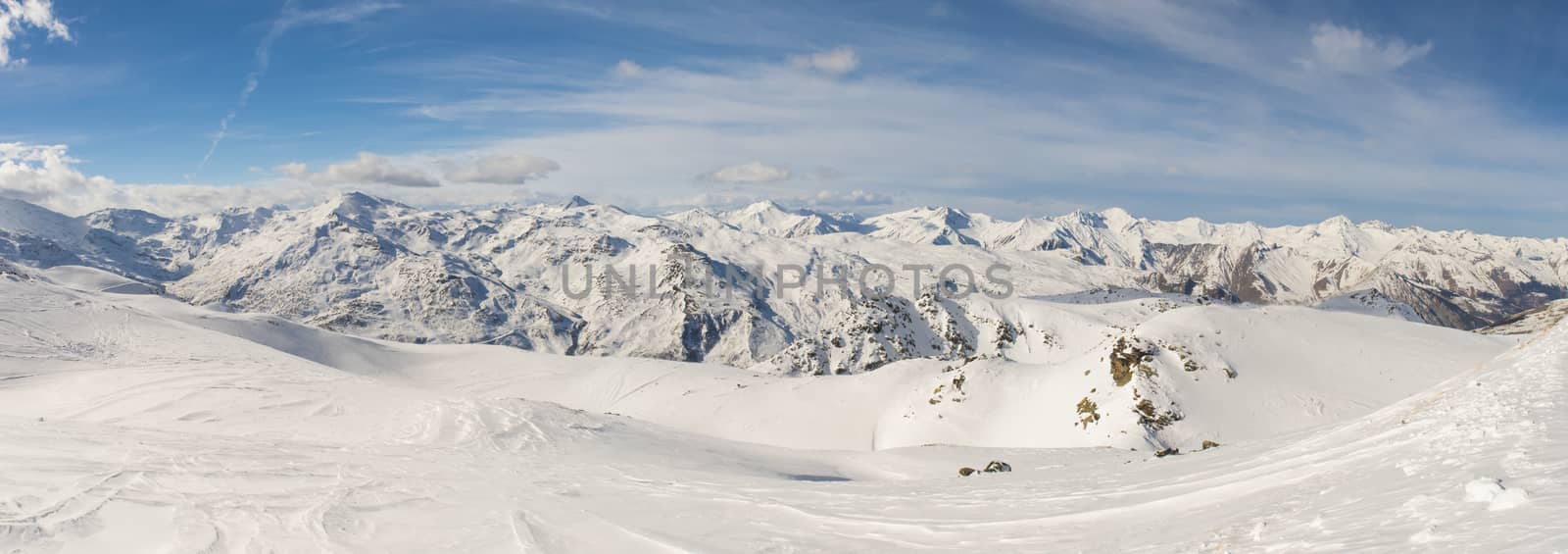Ski slope piste in winter alpine resort with european alps mountain range in background