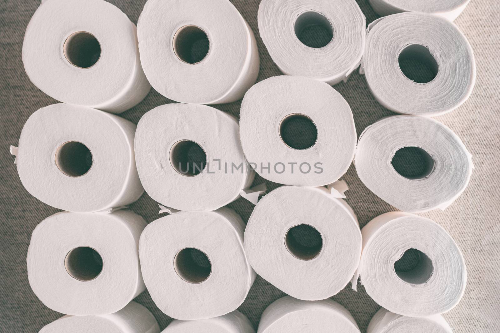 Toilet paper rolls background top flat view of many open rolls. Hoarding of bathroom tissues in fear of store supply shortage during coronavirus COVID-19 panic buying.