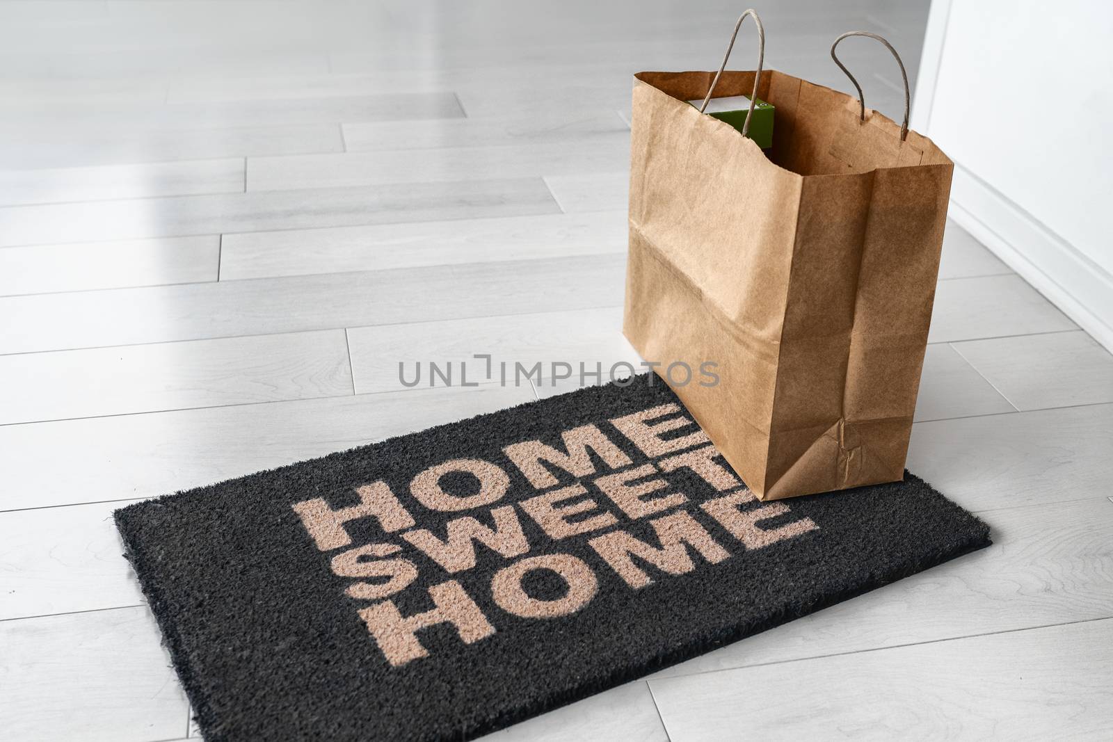 Home delivery of food grocery bag left at door entrance mat for Corona virus prevention safety. Precaution measures against COVID-19, paper shopping bag delivered without contact by Maridav