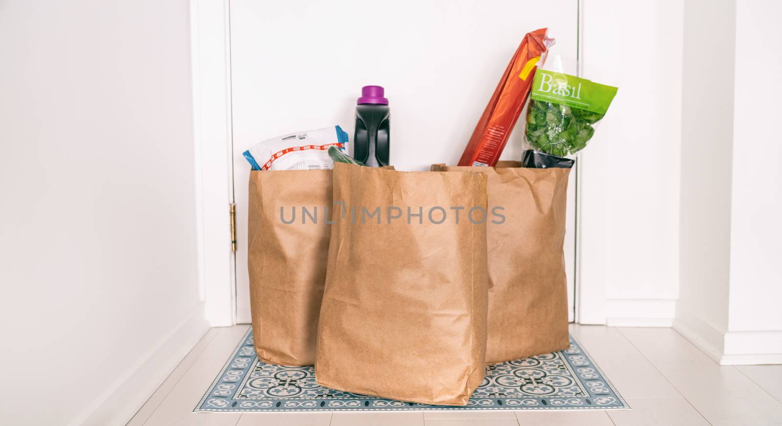 Grocery online delivery receiving grocery bags at home entrance door outside doorstep hallway contactless reception of food deliveries during quarantine COVID-19 Coronavirus.