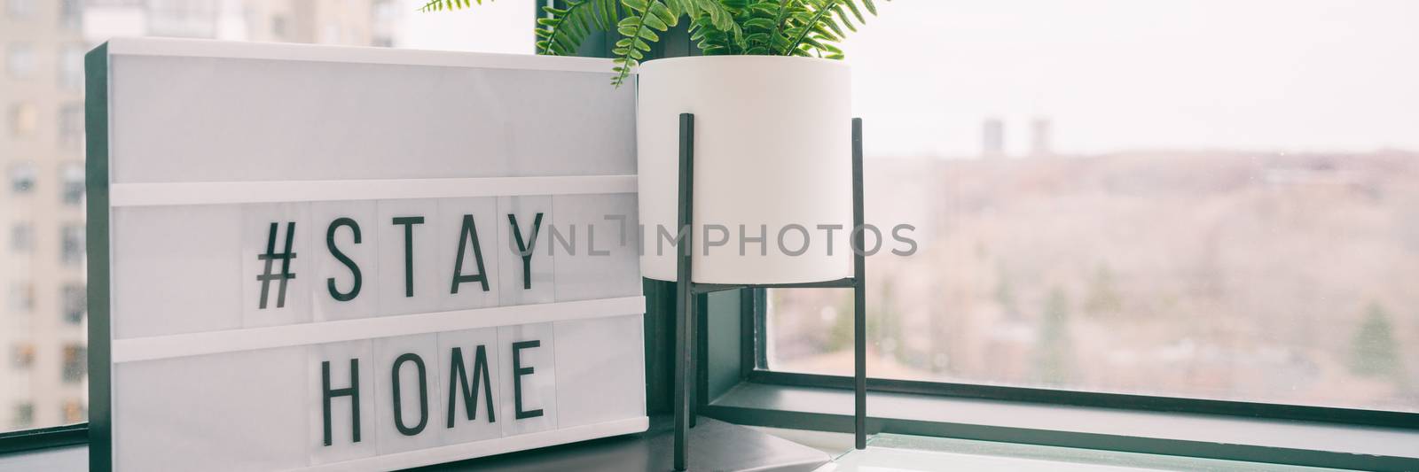 COVID-19 banner Coronavirus staying at home lightbox message sign with text hashtag STAYHOME glowing in light to promote self isolation, staying at home header background.